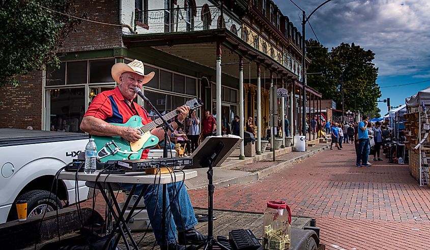 Country singer busking on streets in downtown Lebanon, Illinois. Image credit RozenskiP via Shutterstock.